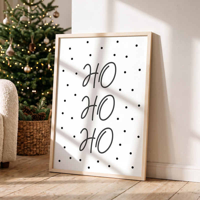 Weihnachtsposter Ho Ho Ho im Holzrahmen in einem hellen Wohnzimmer