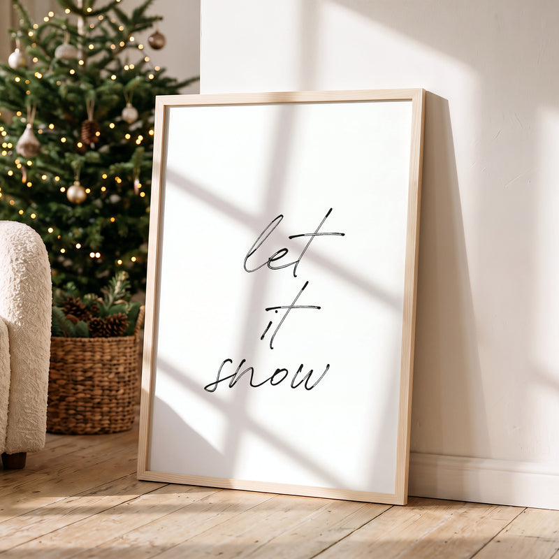 Weihnachtsposter Let It Snow im Holzrahmen in einem hellen Wohnzimmer
