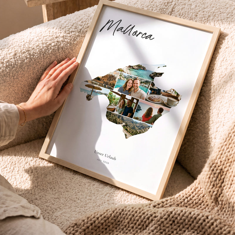Urlaubsposter Mallorca im hellen Holzrahmen, auf dem Sofa gehalten: Fotocollage aus Urlaubsfotos im Umriss, darüber der Name in Handschrift
