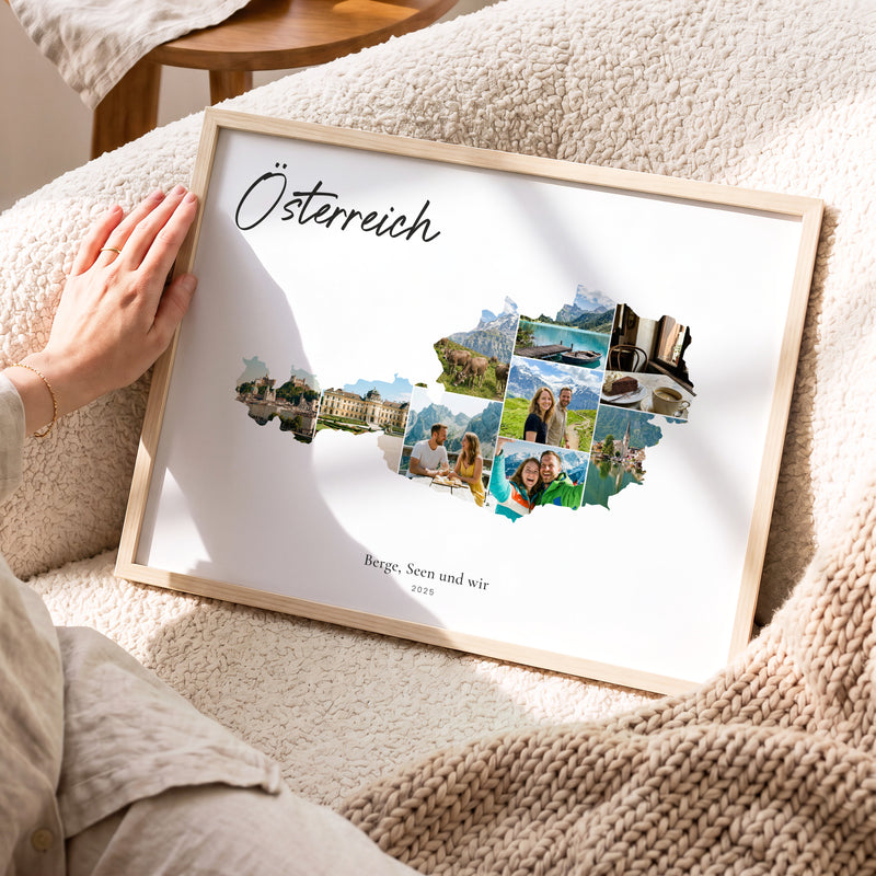 Urlaubsposter Österreich im hellen Holzrahmen, auf dem Sofa gehalten: Fotocollage aus Urlaubsfotos im Umriss, darüber der Name in Handschrift