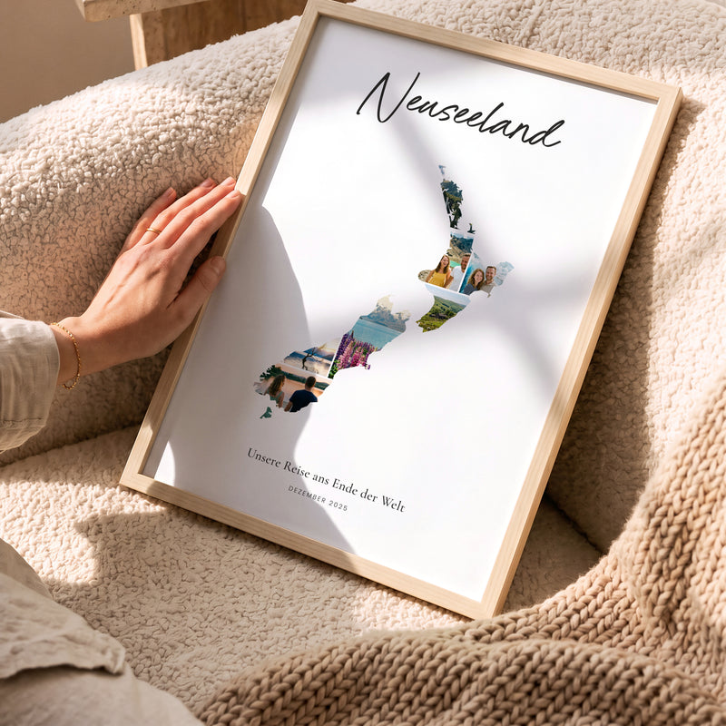 Urlaubsposter Neuseeland im hellen Holzrahmen, auf dem Sofa gehalten: Fotocollage aus Urlaubsfotos im Umriss, darüber der Name in Handschrift