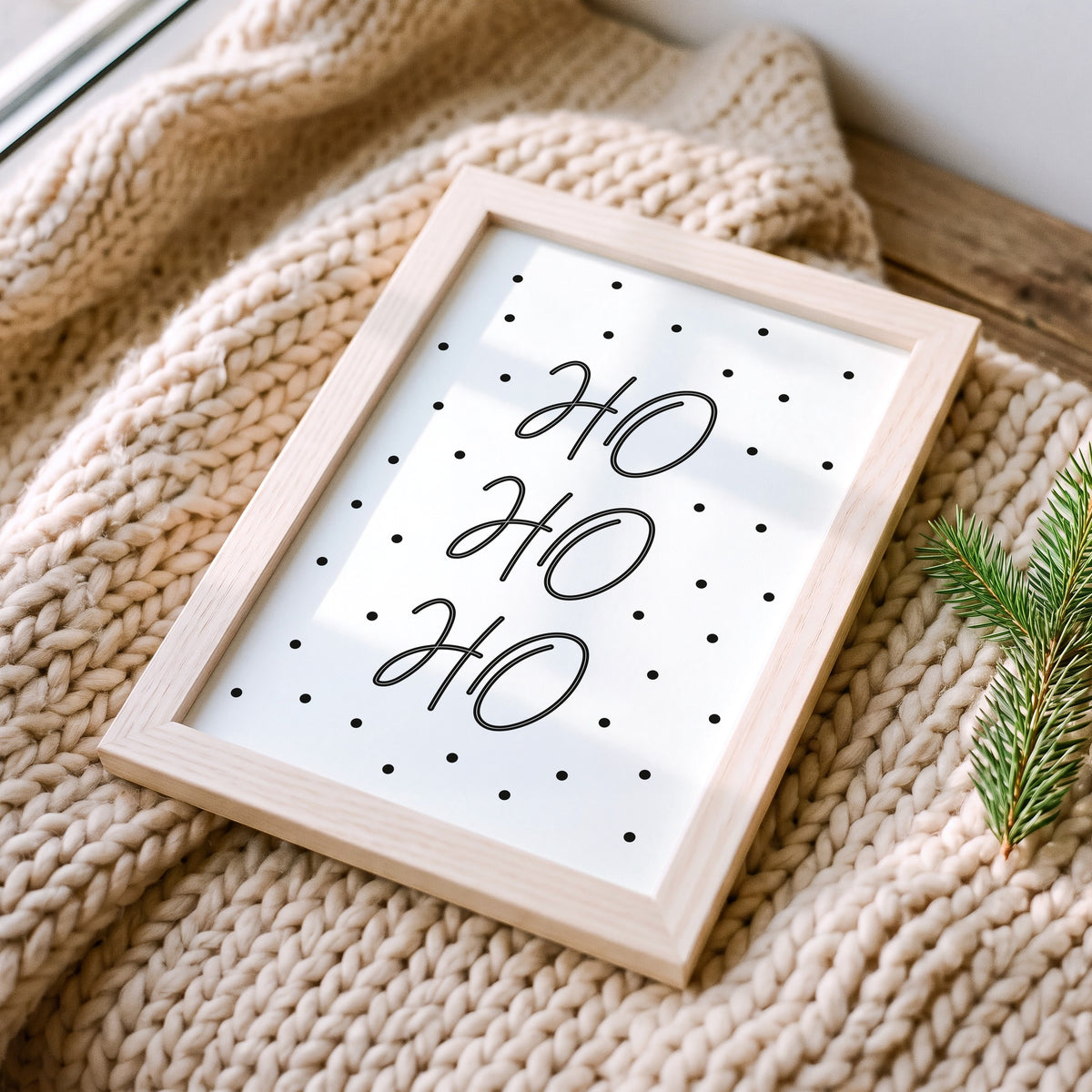 Weihnachtsposter Ho Ho Ho im Holzrahmen auf einer Strickdecke