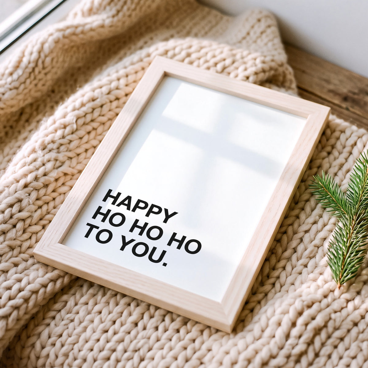 Weihnachtsposter Happy Ho Ho Ho im Holzrahmen auf einer Strickdecke