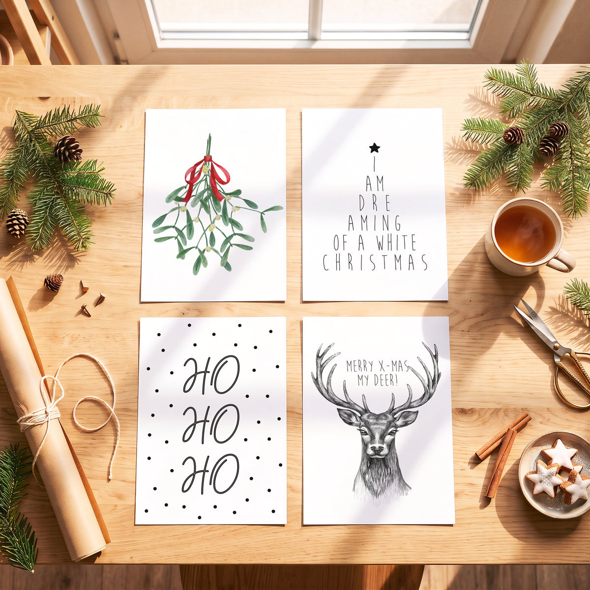 Weihnachtsposter Ho Ho Ho mit weiteren Motiven der Serie auf einem Tisch