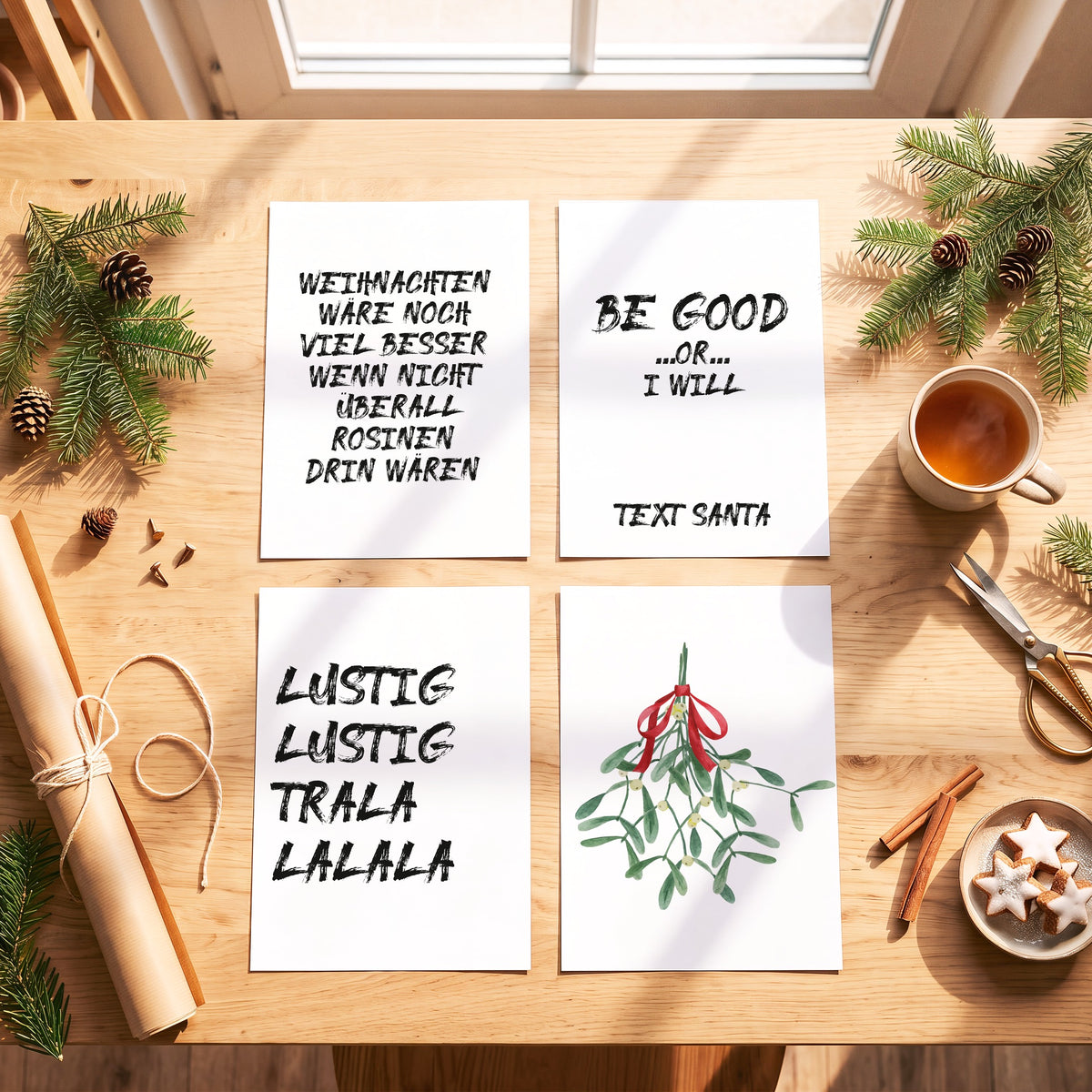 Weihnachtsposter Lustig Lustig mit weiteren Motiven der Serie auf einem Tisch