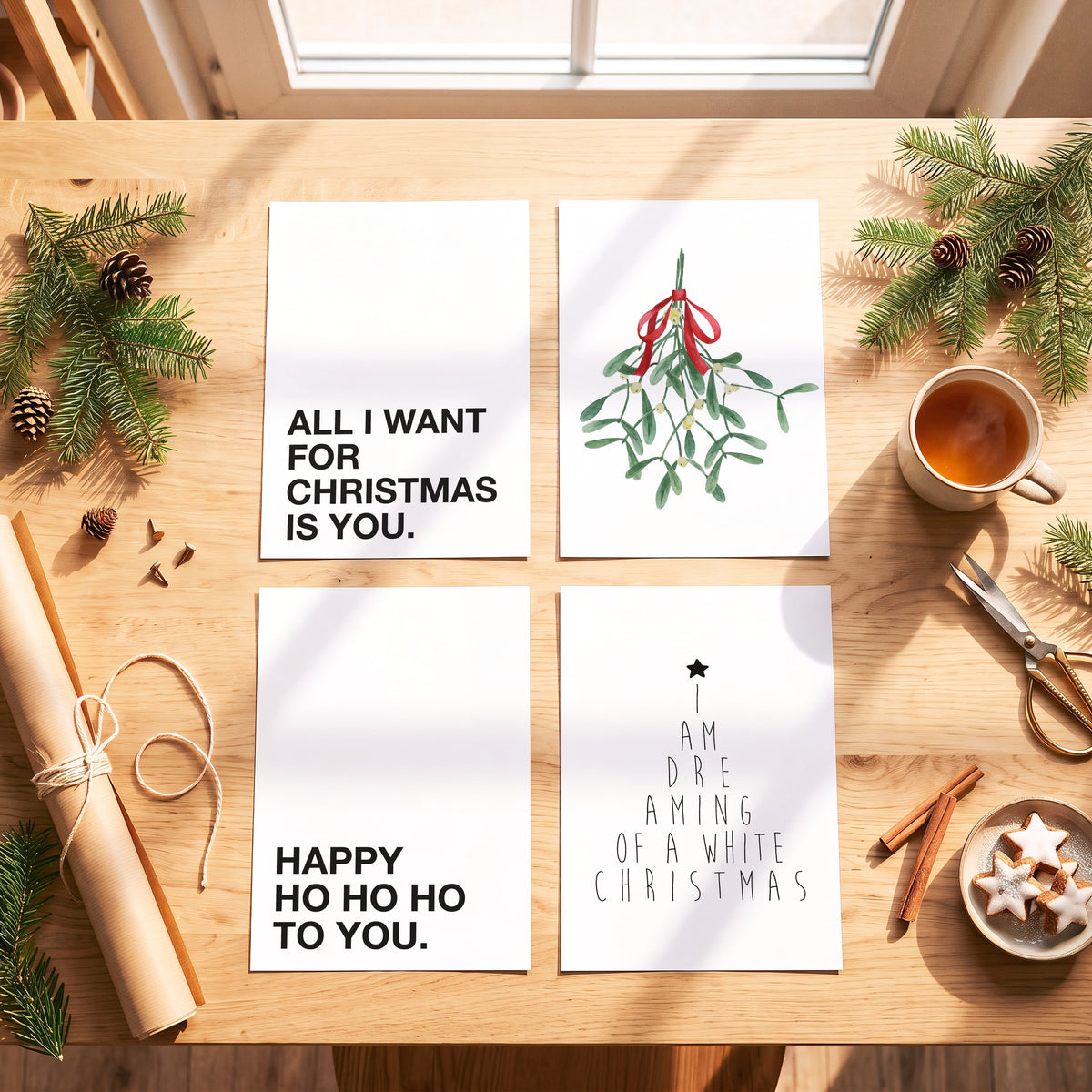 Weihnachtsposter Happy Ho Ho Ho mit weiteren Motiven der Serie auf einem Tisch