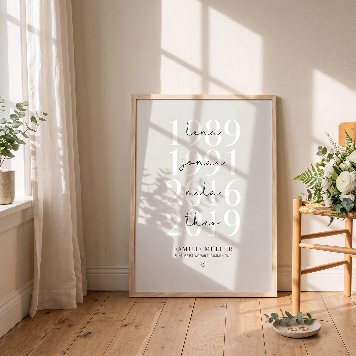 Großes Familienposter mit Jahreszahlen im hellen Holzrahmen an die Wand gelehnt, daneben ein Holzstuhl mit Blumen