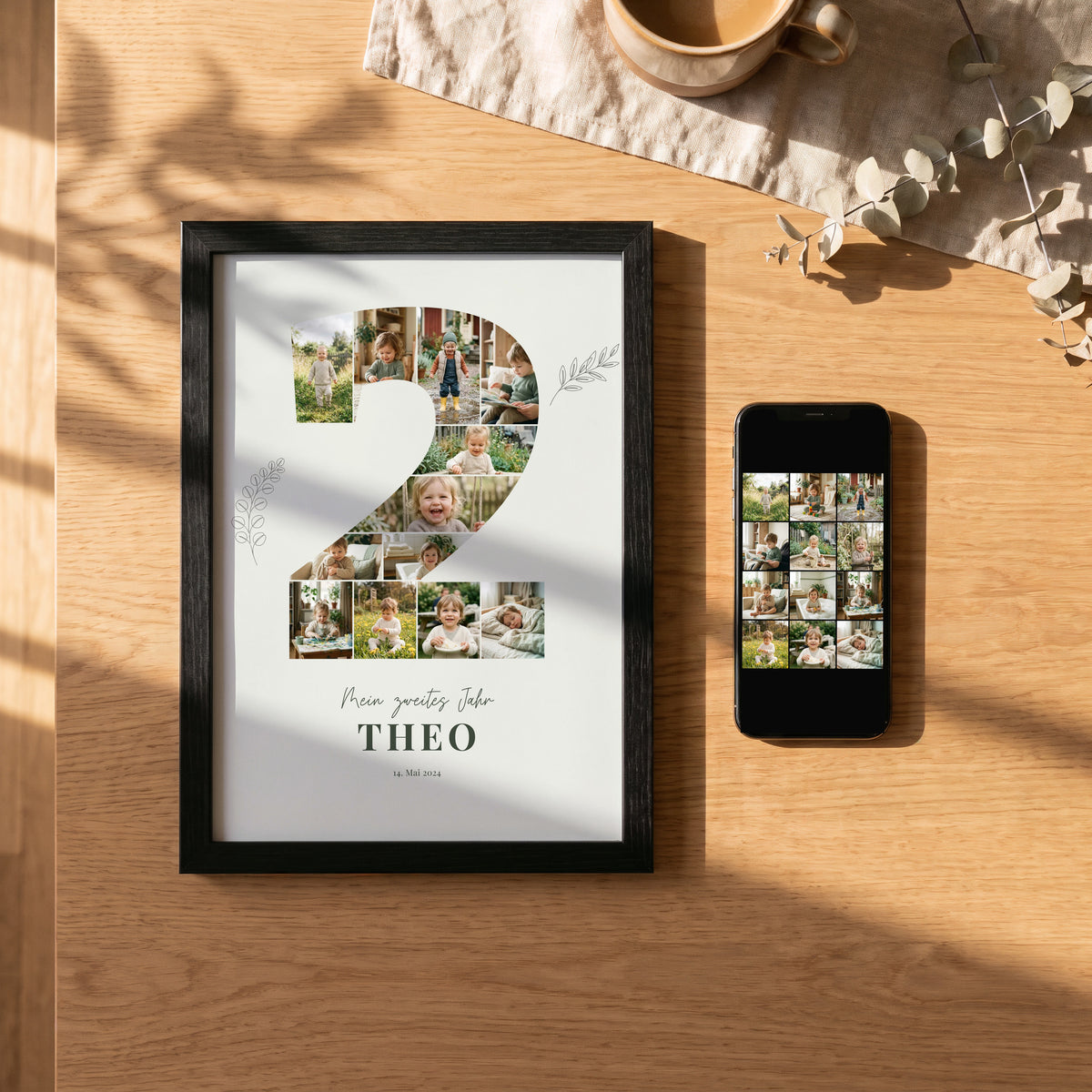 Handy mit Kinderfotos neben dem gerahmten Poster Mein zweites Jahr