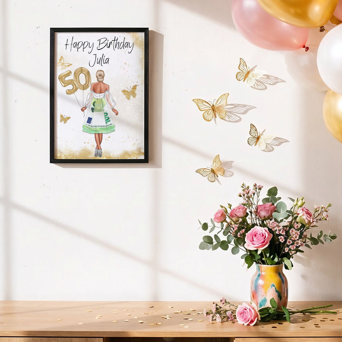 Geburtstagsposter im Rahmen an einer Wand mit goldenen und rosa Luftballons