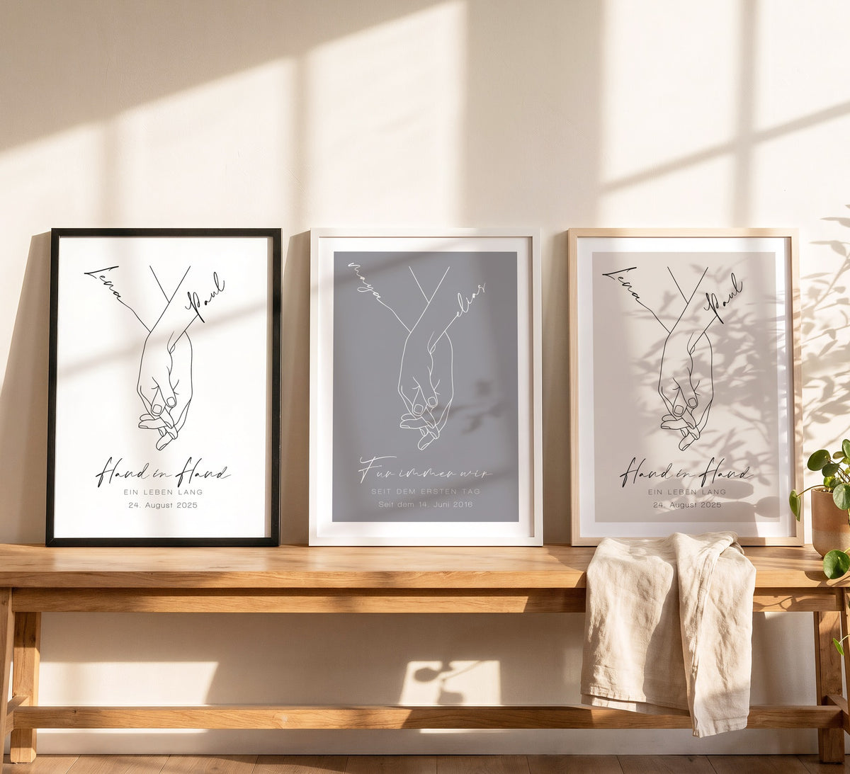 Drei Hand-in-Hand-Poster in Holzrahmen Schwarz, Weiß und Natur hell auf einer Bank