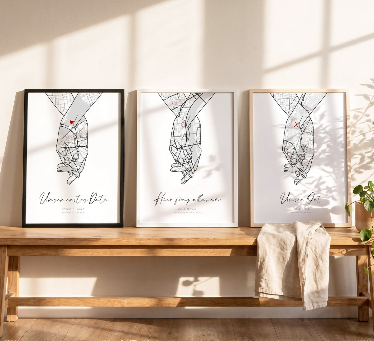 Drei Hand-in-Hand-Kartenposter in Holzrahmen Schwarz, Weiß und Natur hell auf einer Bank
