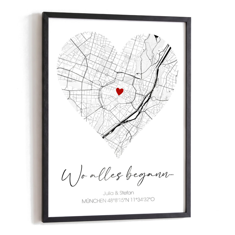 Wo-alles-begann-Poster mit schwarz-weißer Stadtkarte von München in Herzform, rotem Herz, Titel in Schreibschrift, Namen und Koordinaten im schwarzen Holzrahmen auf Weiß