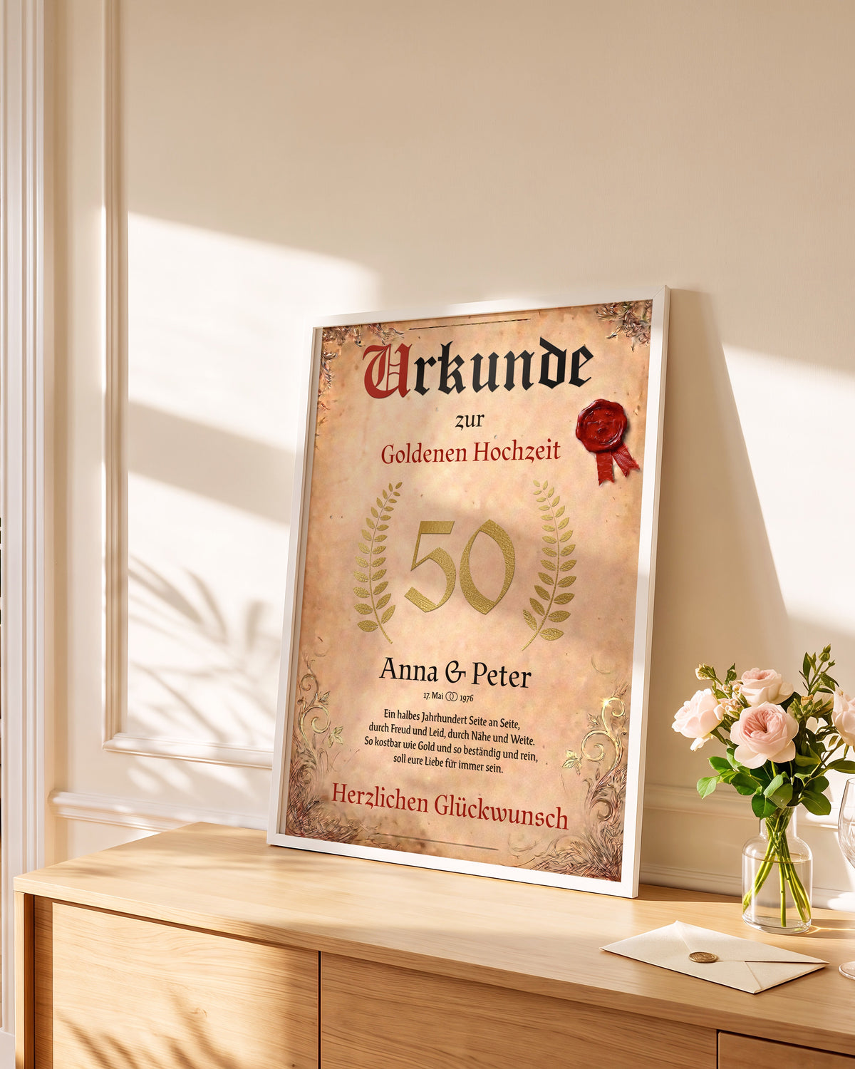 Gerahmte Urkunde zur Goldenen Hochzeit an die Wand gelehnt auf einer Kommode, daneben Rosen und ein Briefumschlag
