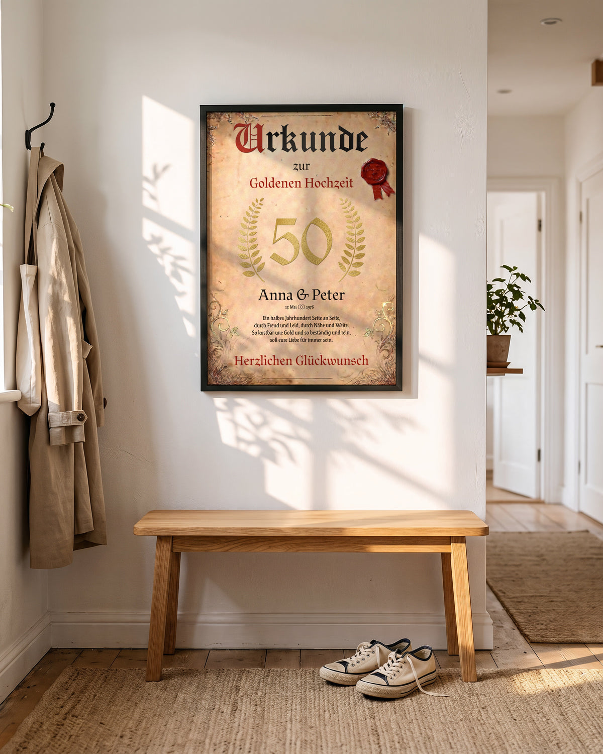 Urkunde zur Goldenen Hochzeit in DIN A2 im schwarzen Holzrahmen an der Wand über einer Bank im Flur