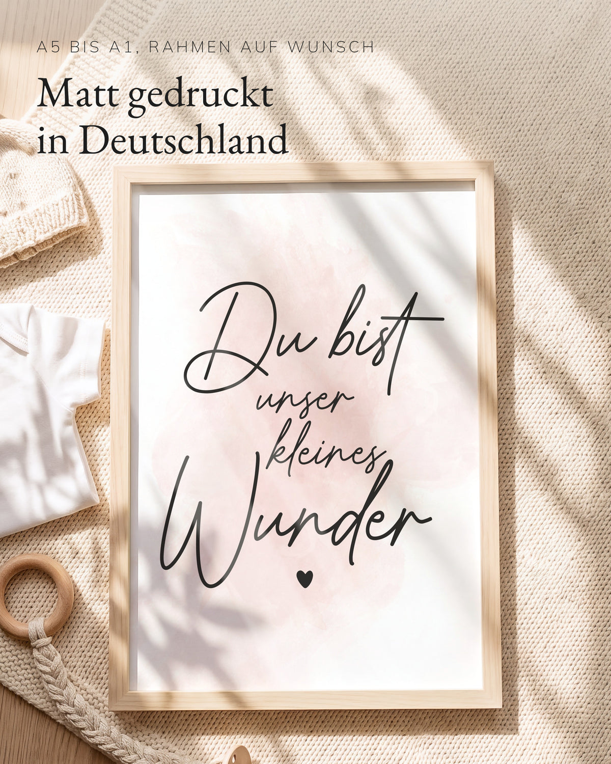 Kinderposter Du bist unser kleines Wunder rosa im Holzrahmen auf einer Strickdecke