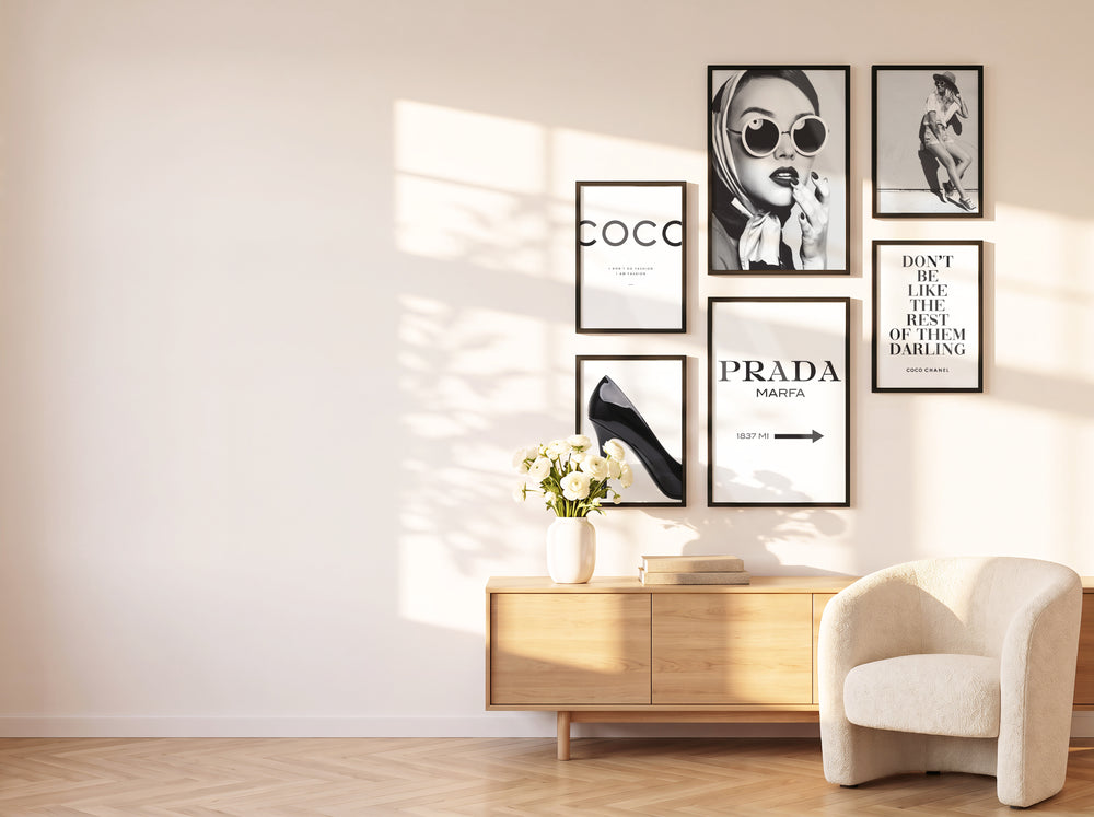 Schwarz-weißes Posterset in schwarzen Holzrahmen an einer sonnigen Wohnwand