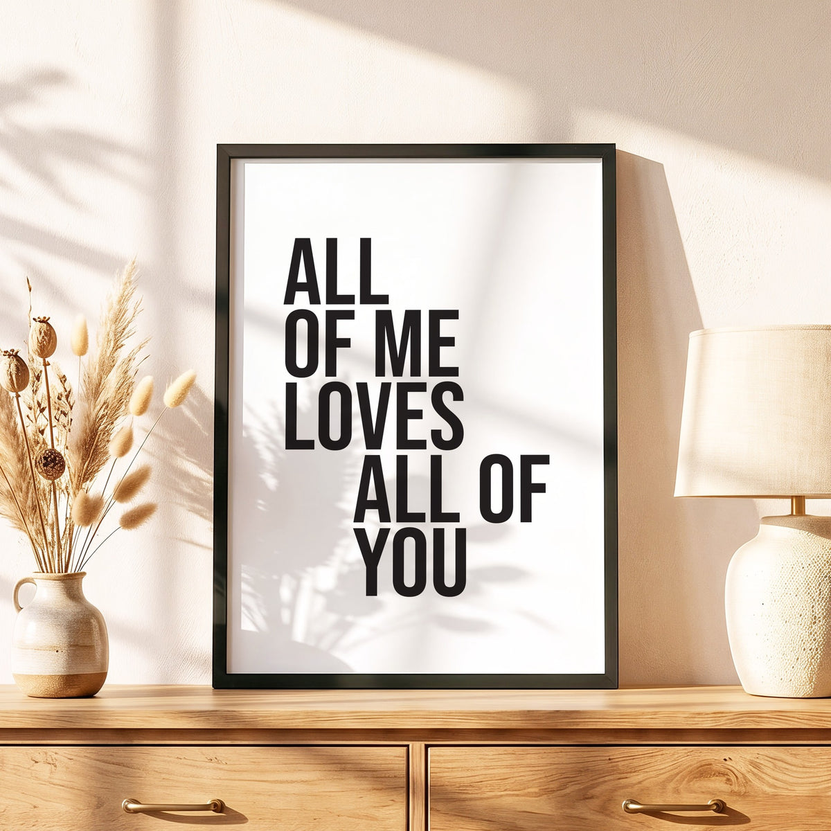 Spruchposter All of me loves all of you im schwarzen Holzrahmen auf einer Kommode