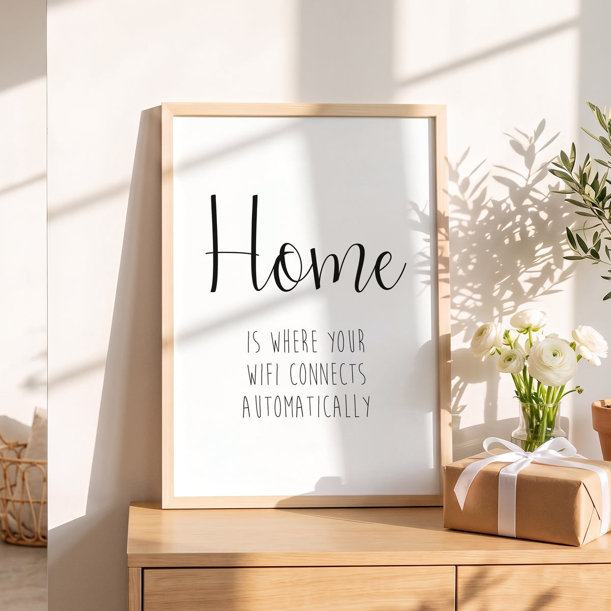Spruchposter Home is where your wifi connects als Geschenk auf dem Sideboard