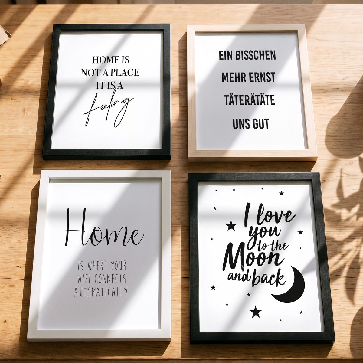 Spruchposter Home is where your wifi connects mit weiteren Motiven der Reihe auf dem Tisch