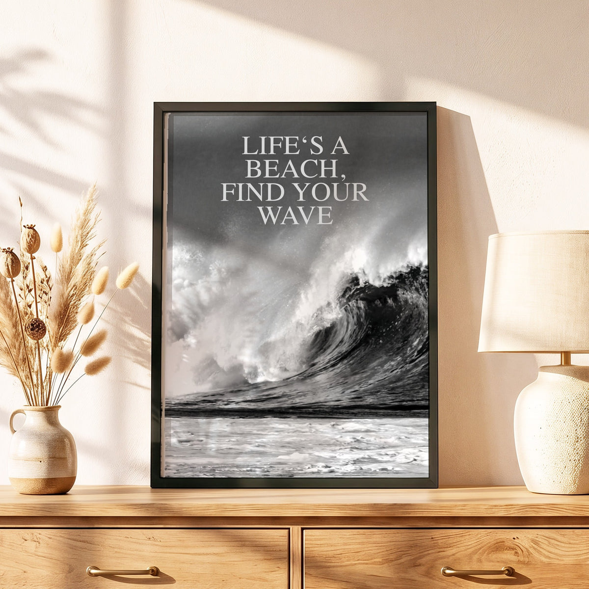 Spruchposter Life's a beach im schwarzen Holzrahmen auf einer Kommode