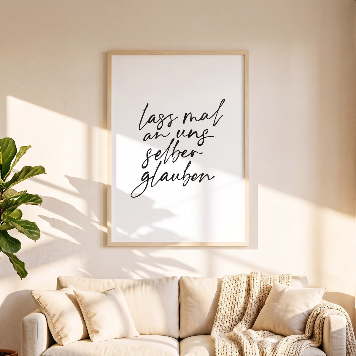 Spruchposter Lass mal an uns selber glauben in 50 x 70 cm über dem Sofa