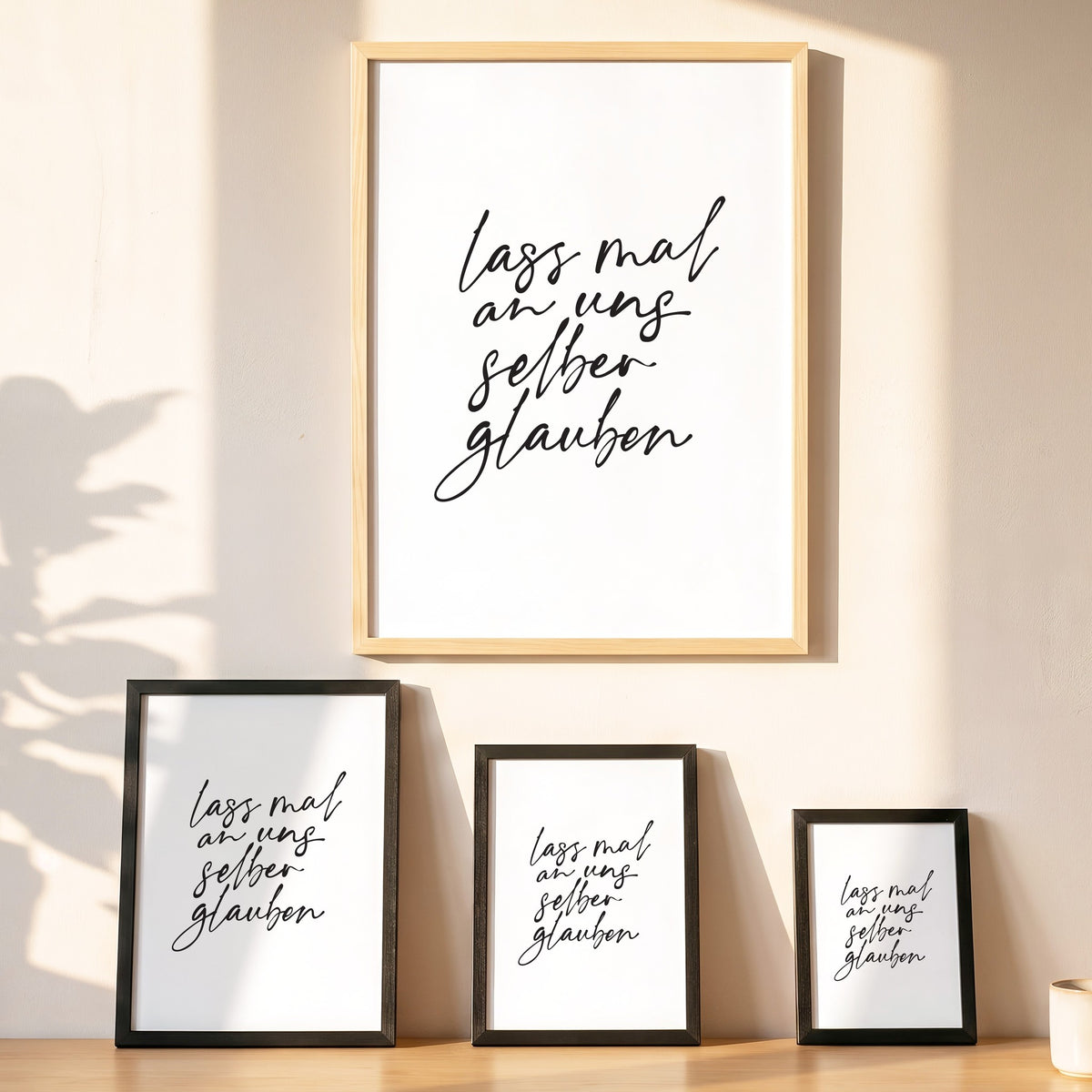 Spruchposter Lass mal an uns selber glauben in vier Größen an der Wand