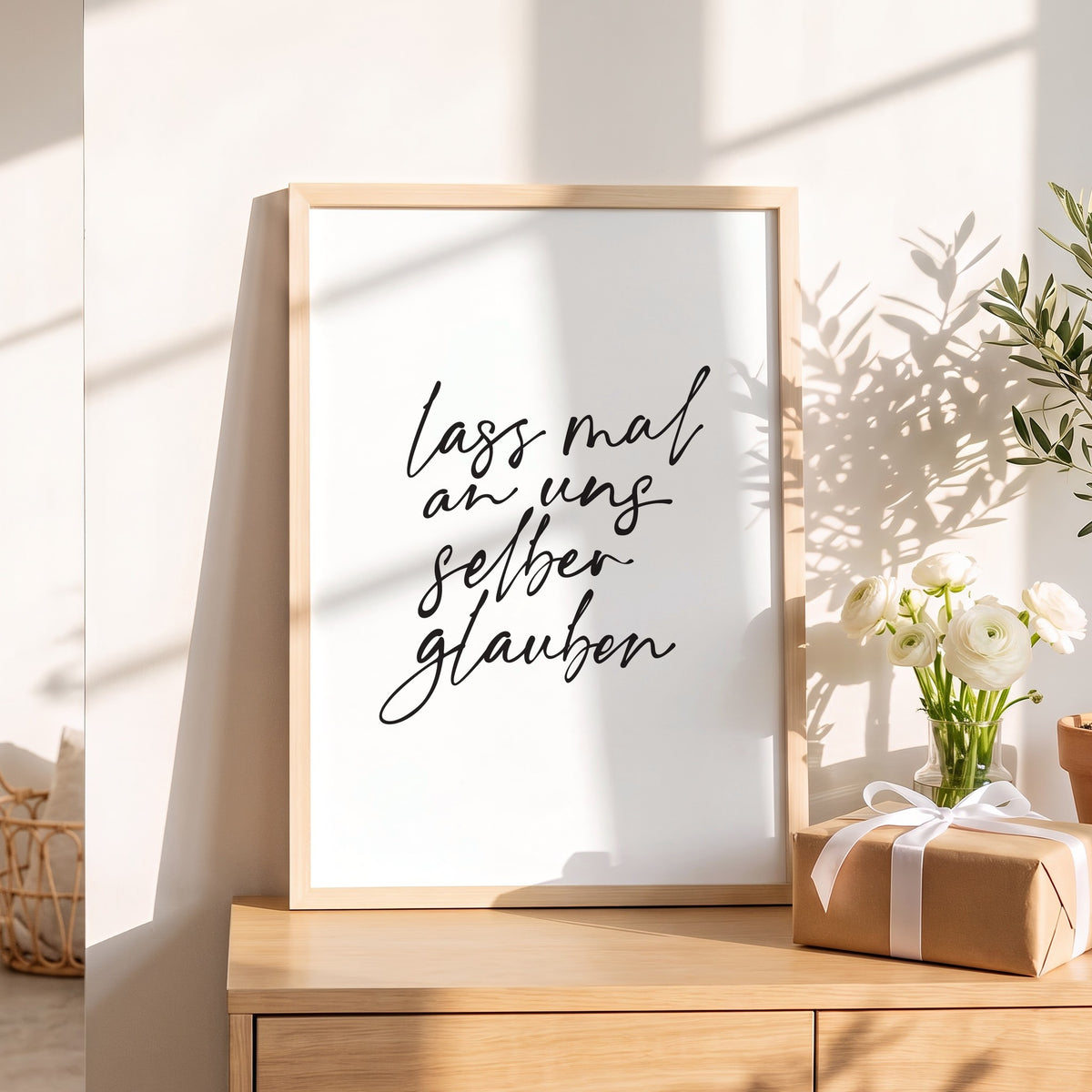 Spruchposter Lass mal an uns selber glauben als Geschenk auf dem Sideboard