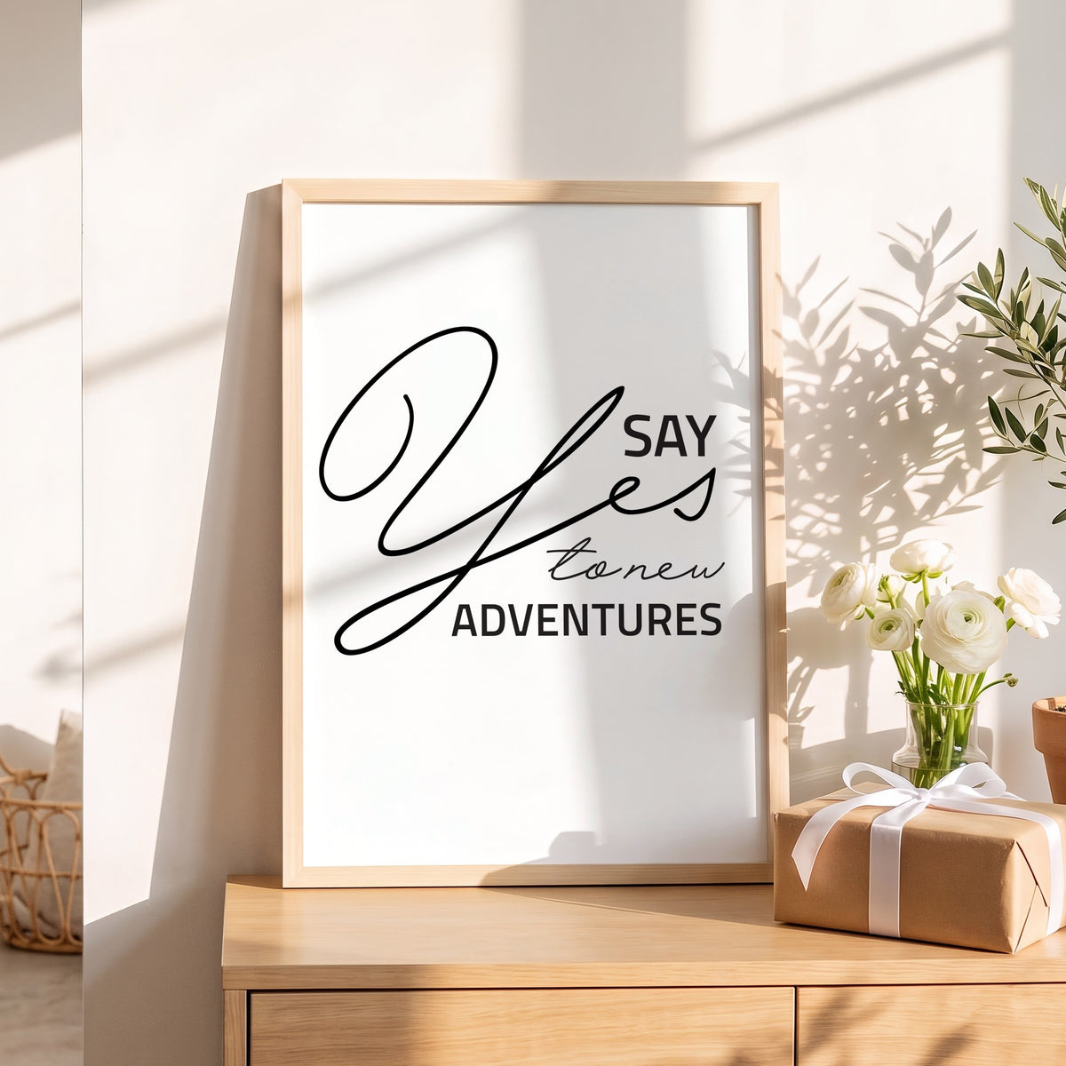 Spruchposter Say yes to new adventures als Geschenk auf dem Sideboard