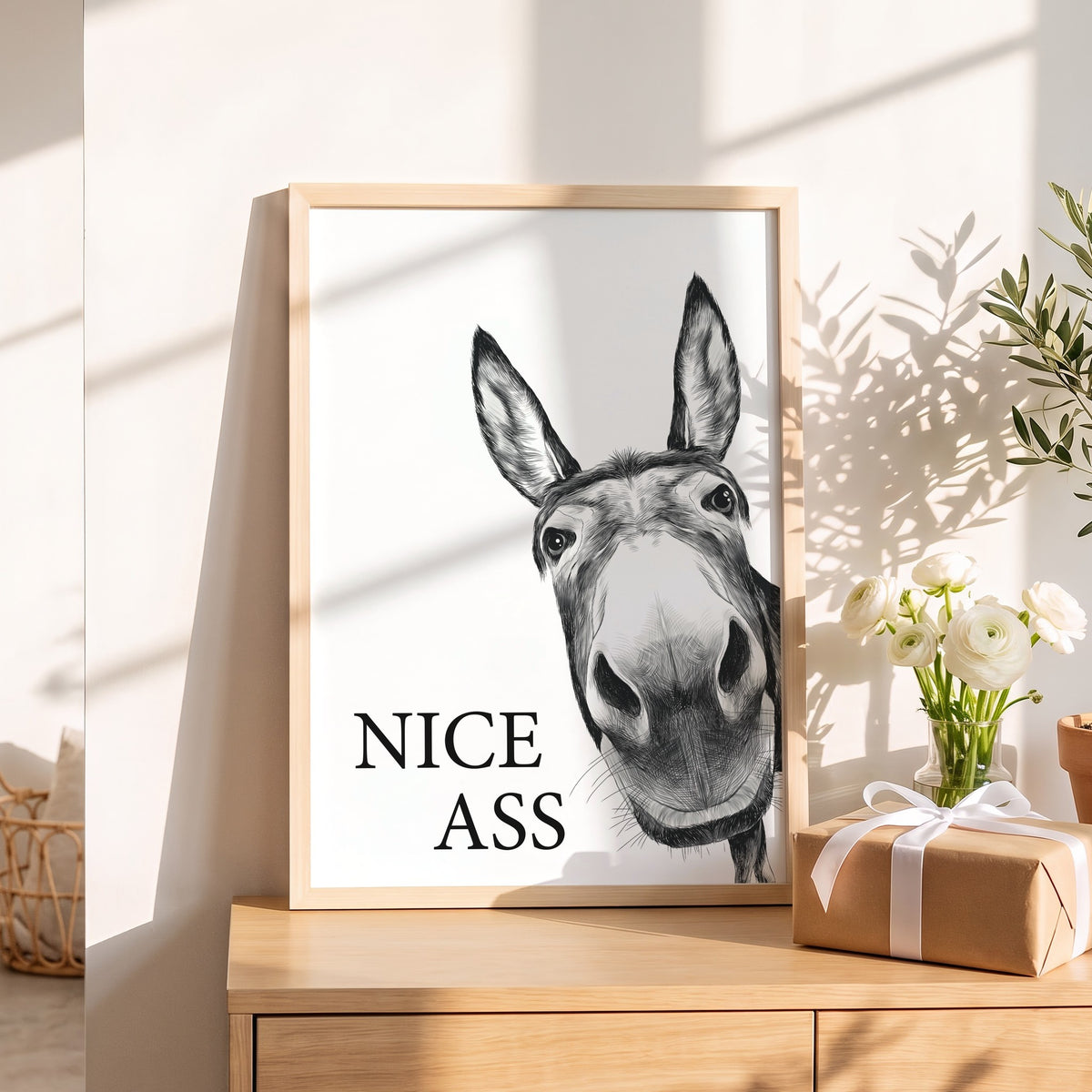 Spruchposter Nice Ass mit Esel als Geschenk auf dem Sideboard