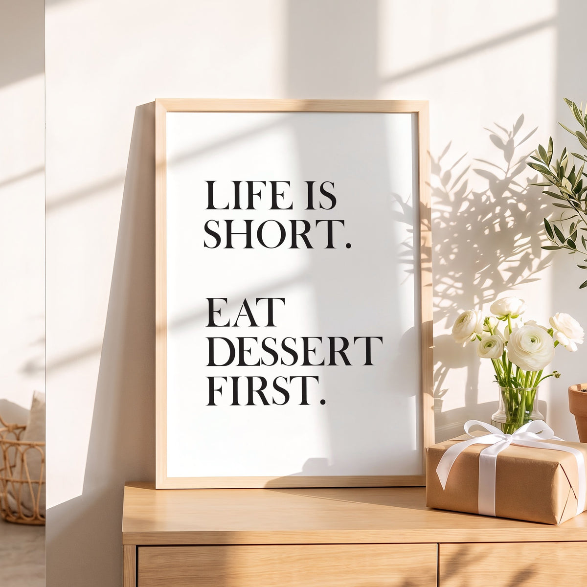 Spruchposter Life is short, eat dessert first als Geschenk auf dem Sideboard