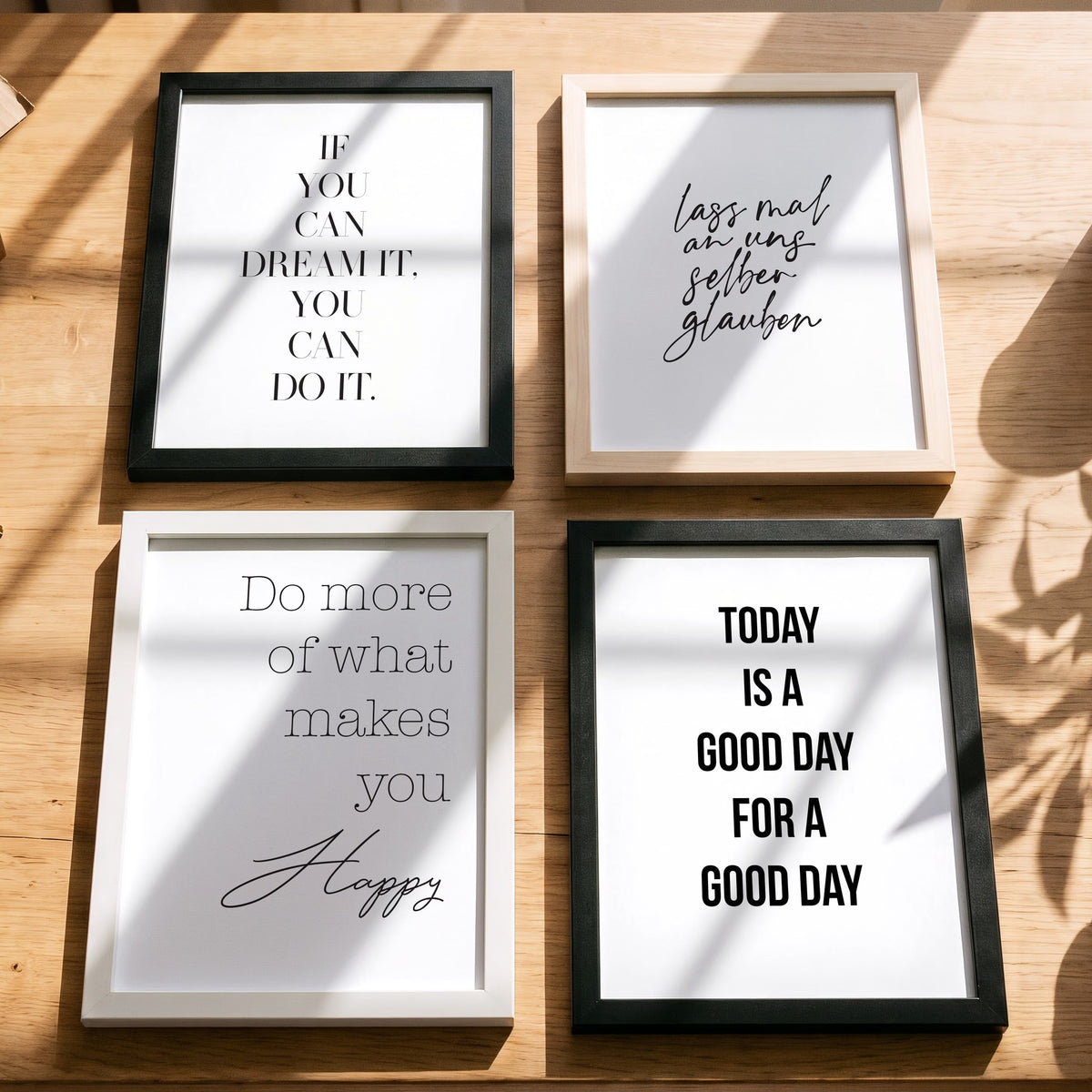 Spruchposter Do more of what makes you happy mit weiteren Motiven der Reihe auf dem Tisch