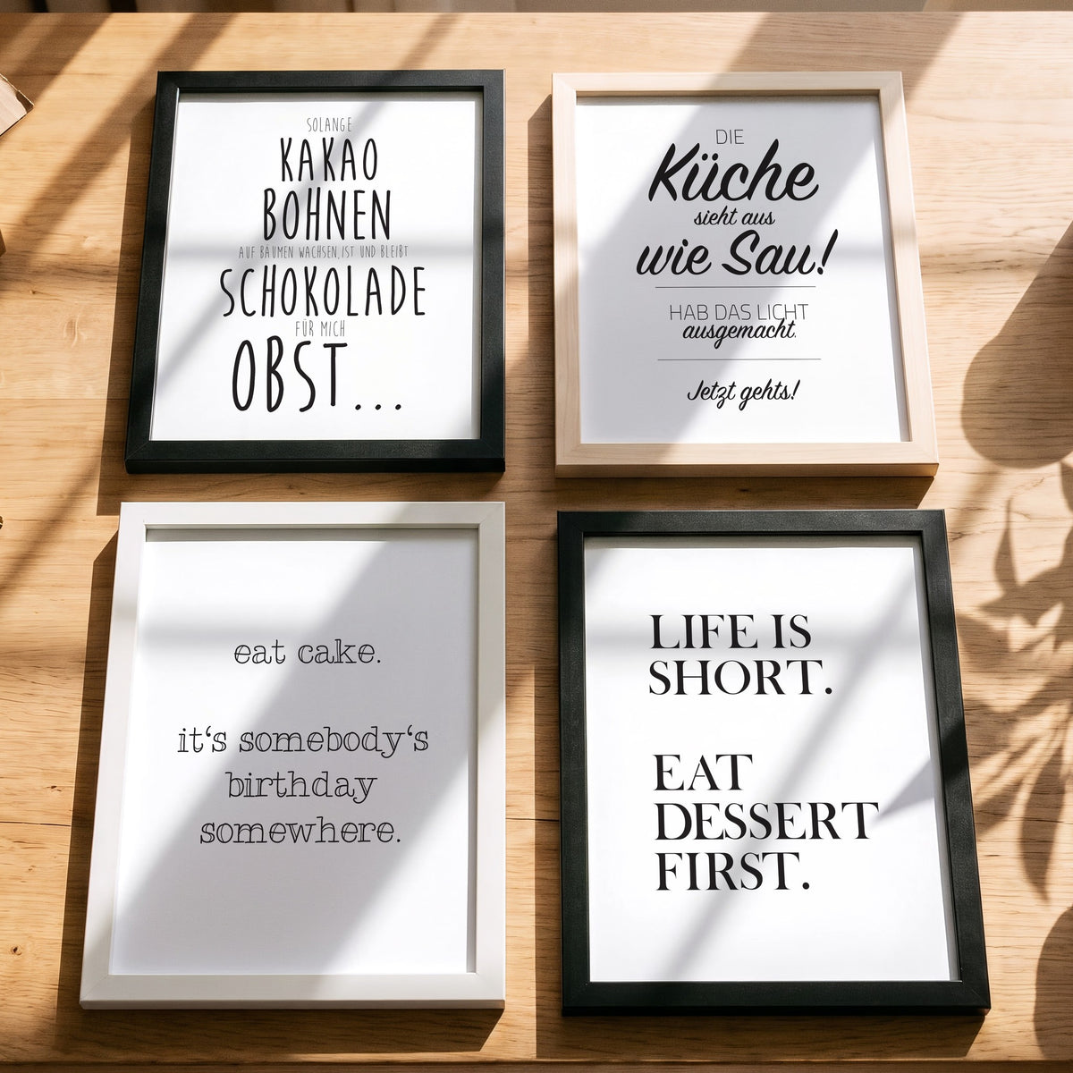 Spruchposter Eat cake mit weiteren Motiven der Reihe auf dem Tisch
