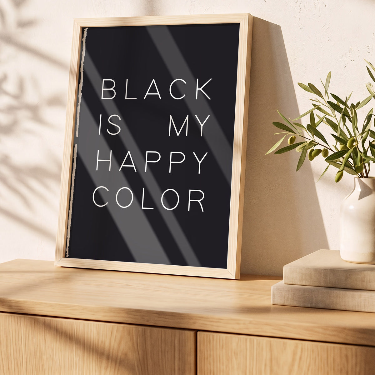 Poster Happy Color Black im Holzrahmen auf einem Sideboard