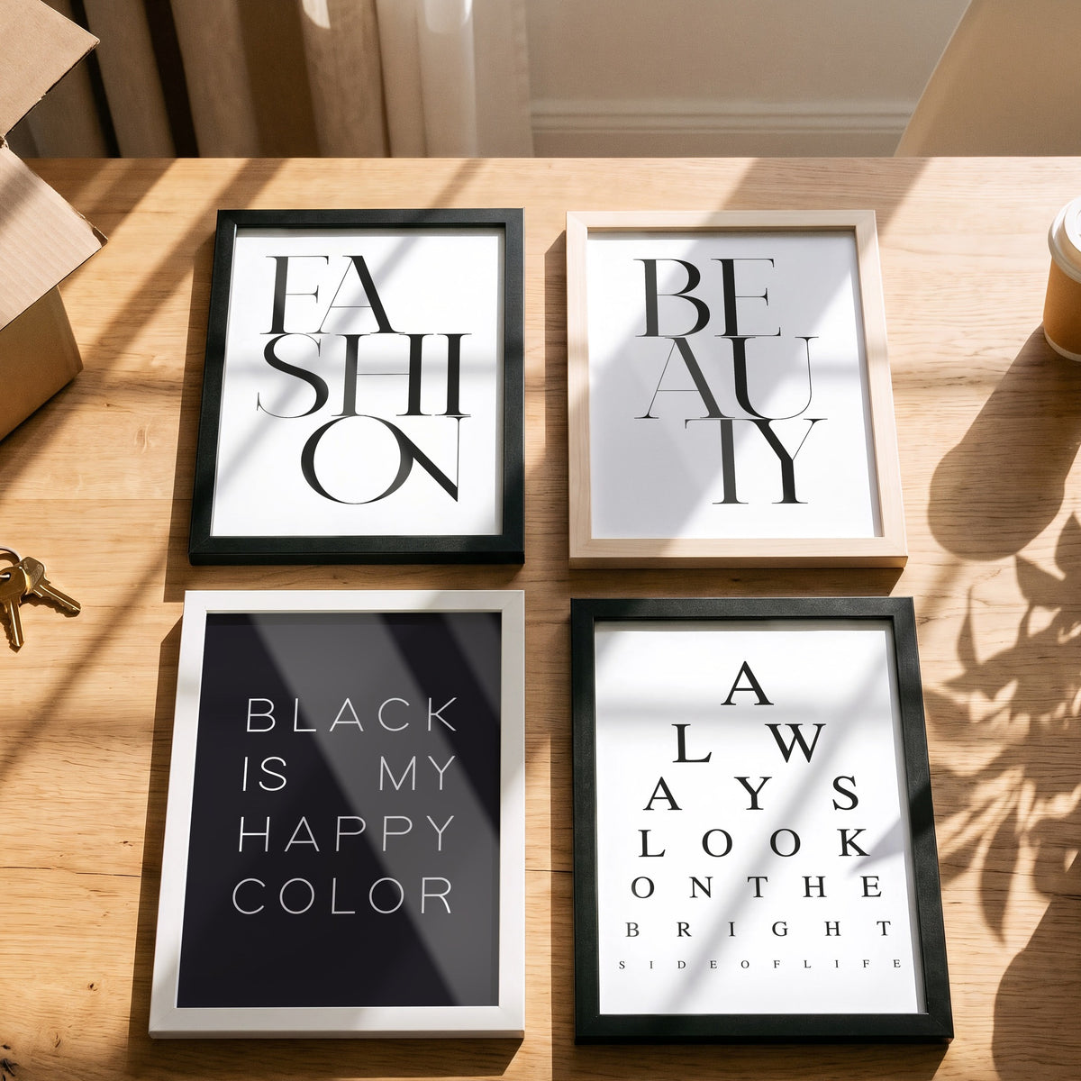 Poster Happy Color Black mit weiteren Motiven der Serie auf einem Tisch