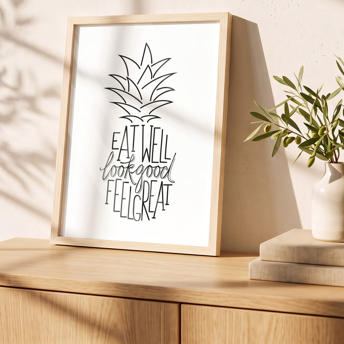 Poster Ananas im Holzrahmen auf einem Sideboard