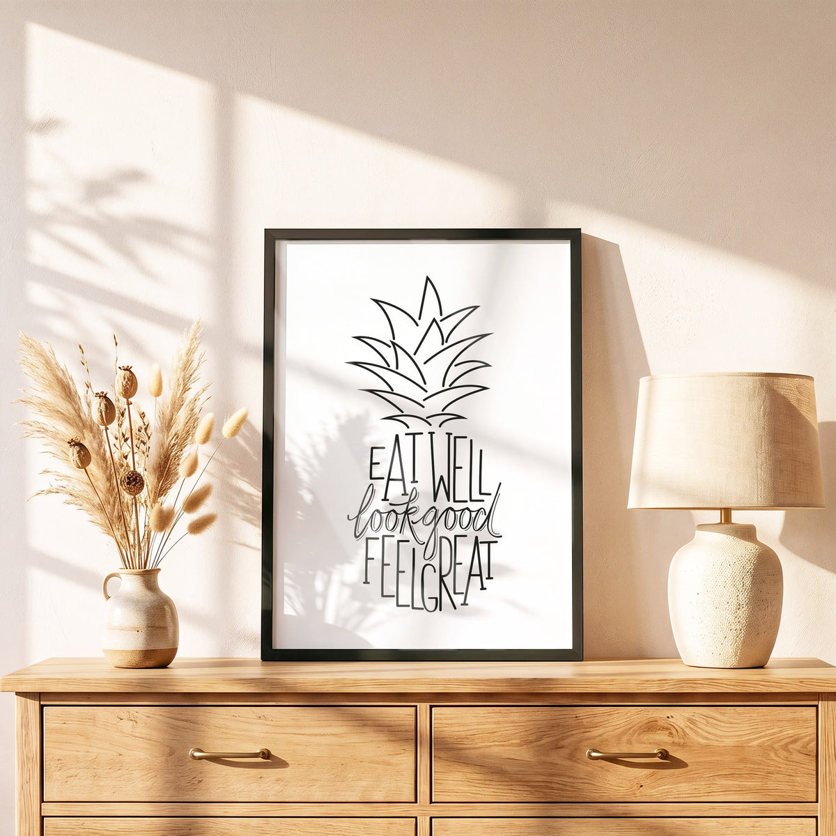Poster Ananas im schwarzen Holzrahmen auf einer Kommode