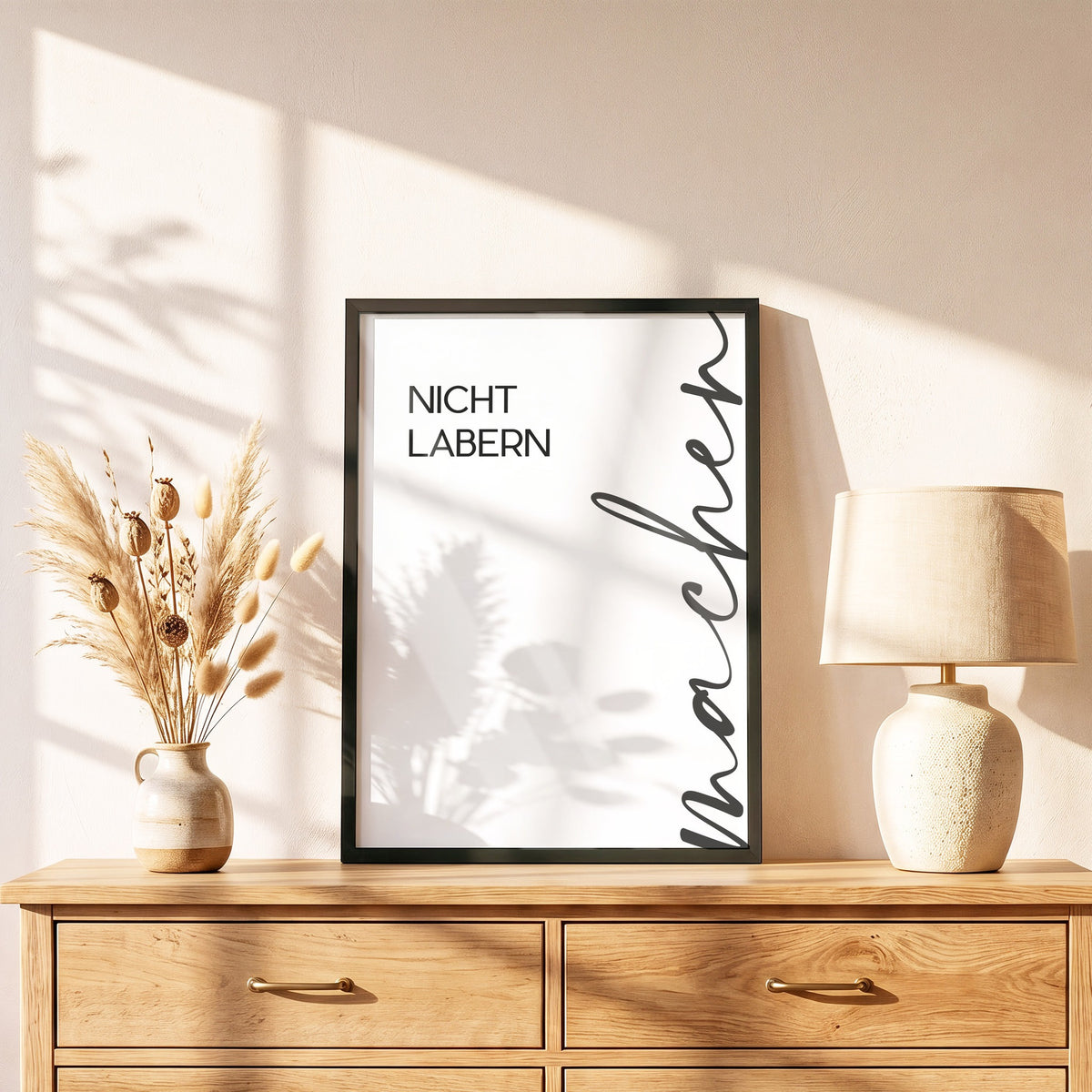 Poster Nicht labern, machen im schwarzen Holzrahmen auf einer Kommode