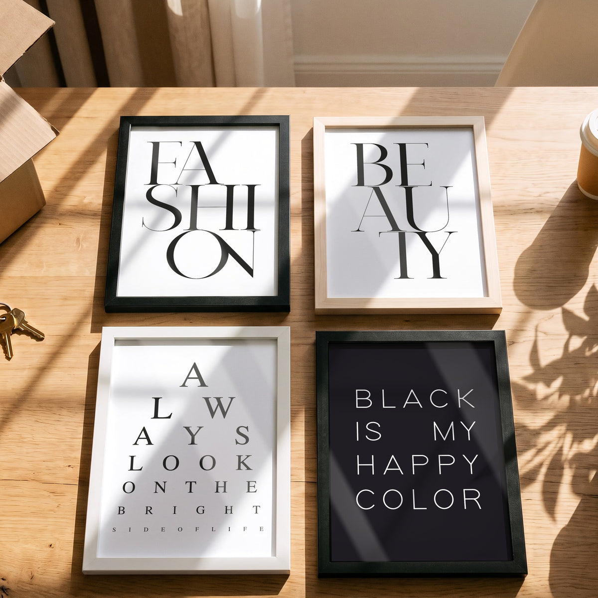 Poster Always look on the bright side of life mit weiteren Motiven der Serie auf einem Tisch