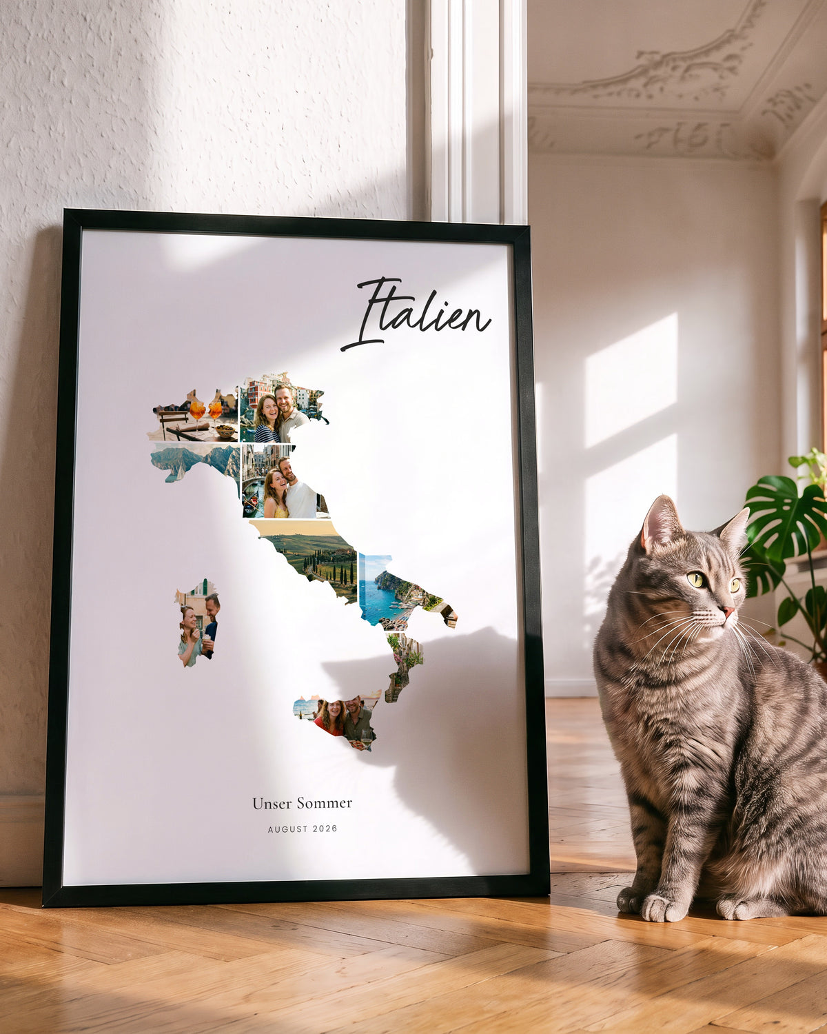 Großes Urlaubsposter 50 × 70 cm im schwarzen Holzrahmen, daneben sitzt eine Katze
